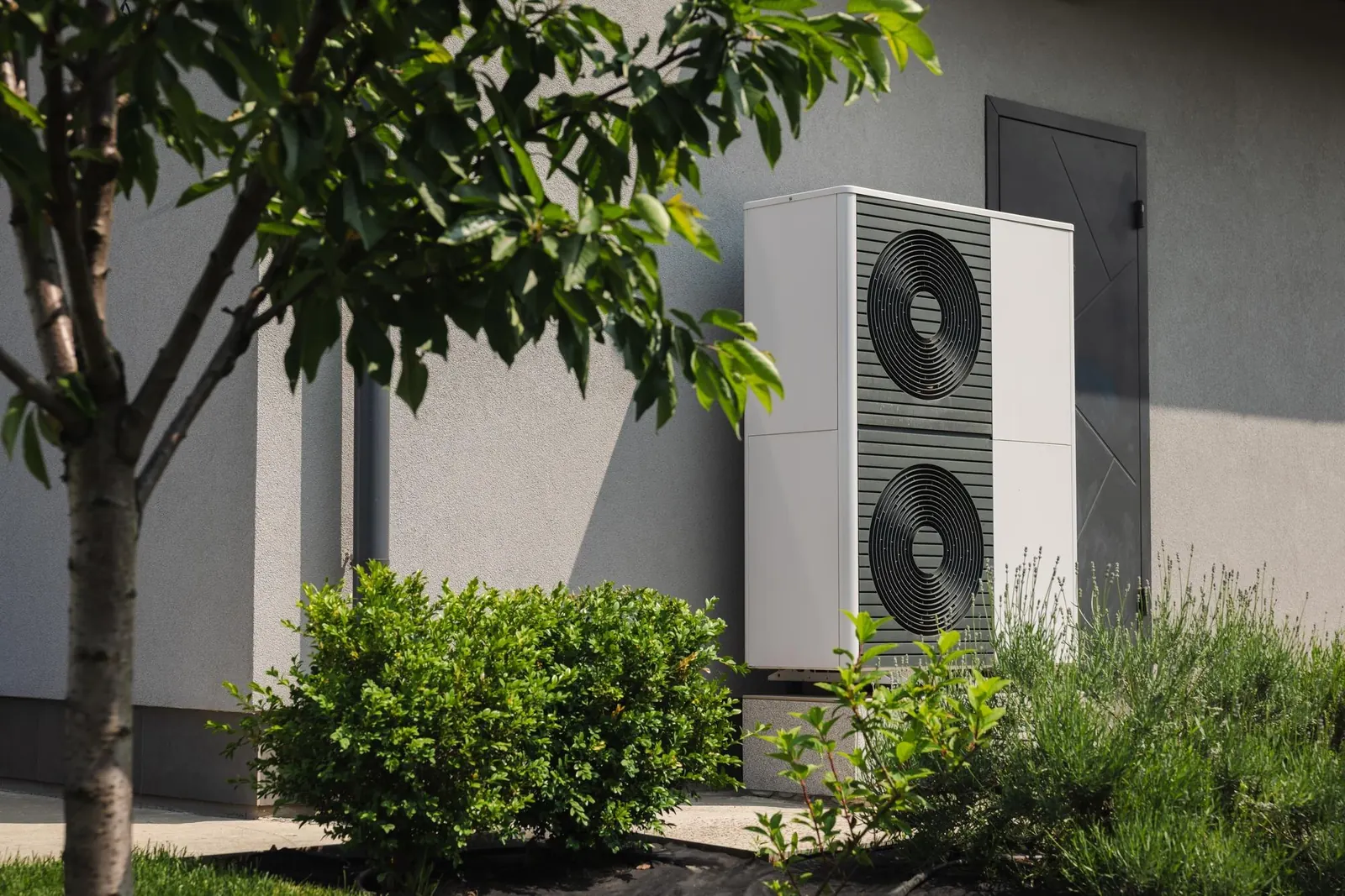 Pompe à chaleur installée près d’une maison avec jardin
